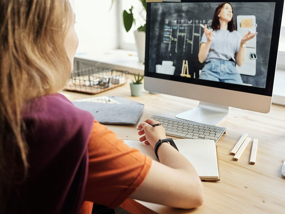 Junge Rrau sitzt vor Monitor